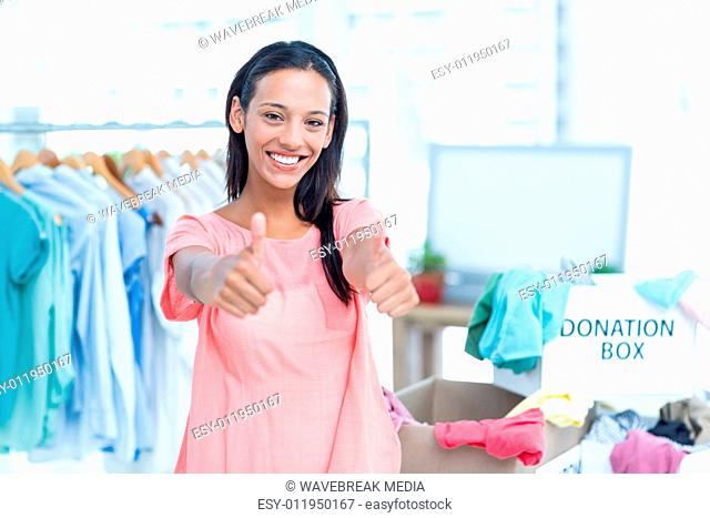 Smiling young female volunteer gesturing thumbs up