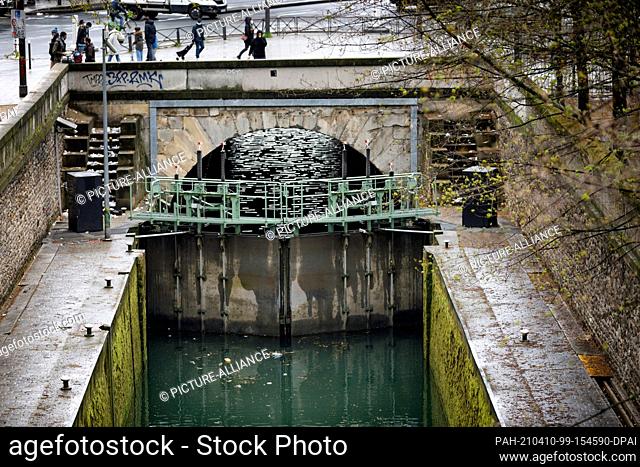 09 April 2021, France, Paris: Garbage accumulates in the Canal Saint Martin. Bulky waste on the sidewalk, overflowing garbage cans