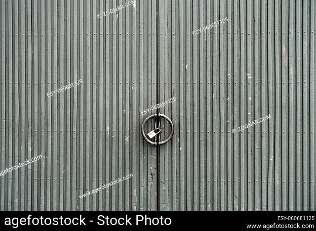 Weathered gray metal door. Rusty iron gate. Urban industrial style