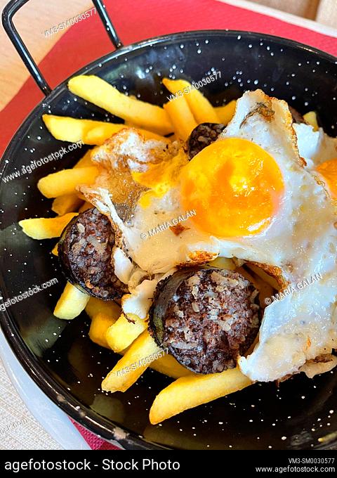 Fried egg with black pudding and chips. Spain