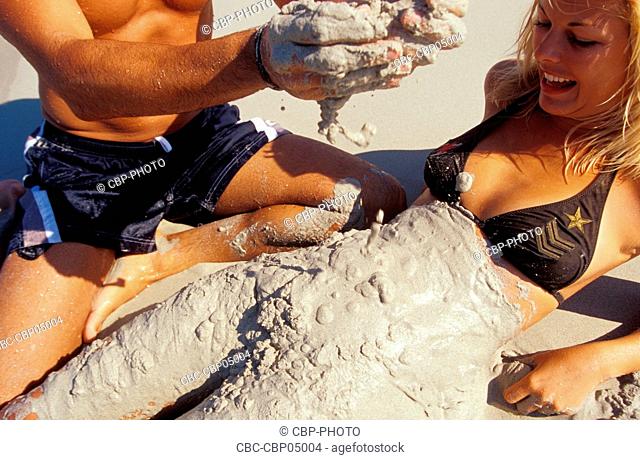 Young Couple at the Beach, Man Putting Wet Sand on Woman