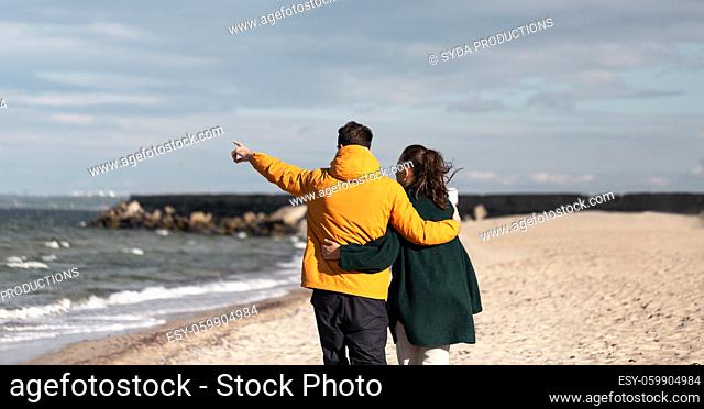 couple walking along autumn beach