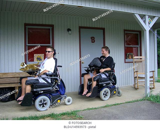 Boys, at camp, racing in their wheelchairs