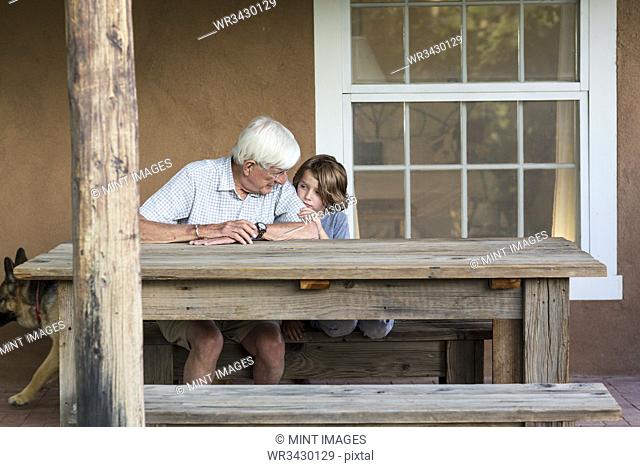 senior granfather talking with his 5 year old grandson