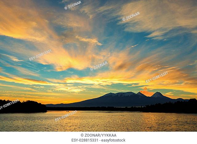 Beautiful sunrise over volcanoes Kluchevskaya group with reflection in the river Kamchatka