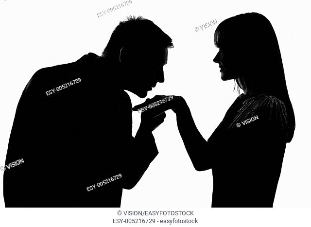one caucasian man kissing hand woman in studio silhouette isolated on white background