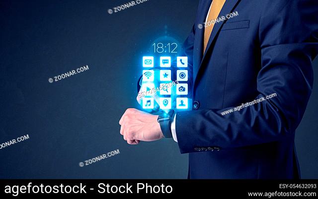 Businessman wearing smartwatch with application icons