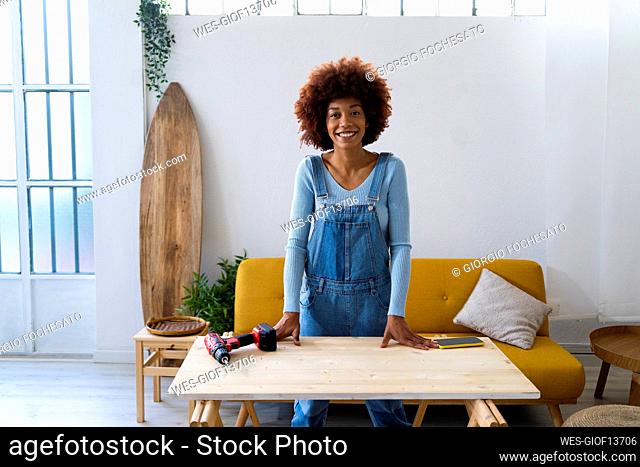 Redhead Afro woman standing at table in living room