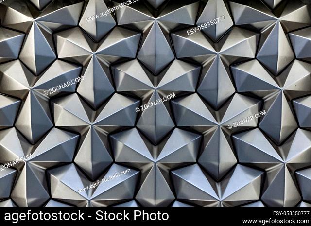 Abstract silver metal background. Geometric metal pattern angular cladding. Modern wallpaper backdrop