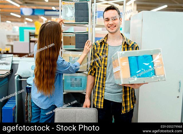 Young love couple choosing core of mattress in furniture store showroom. Man and woman looking samples for bedroom in shop