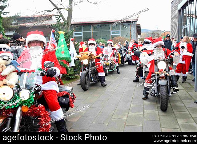 06 December 2023, Rhineland-Palatinate, Neustadt an der Weinstraße: Motorcyclists dressed up as Santas sit on their bikes