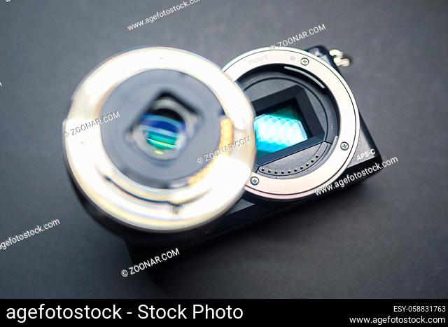 Close-up of mirrorless digital APS-C camera with deattached lens. Shot form above