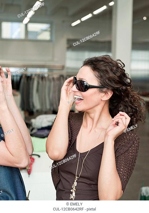 women shopping trying on sunglasses