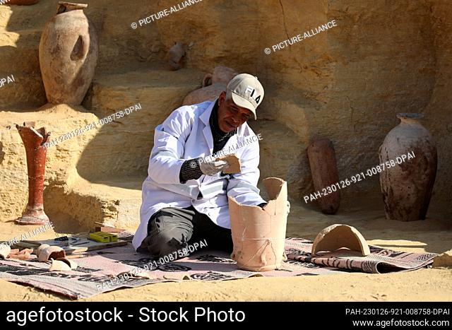 26 January 2023, Egypt, Giza: An Egyptian archaeologist restores some antiquotes at the site of the Step Pyramid of Djoser