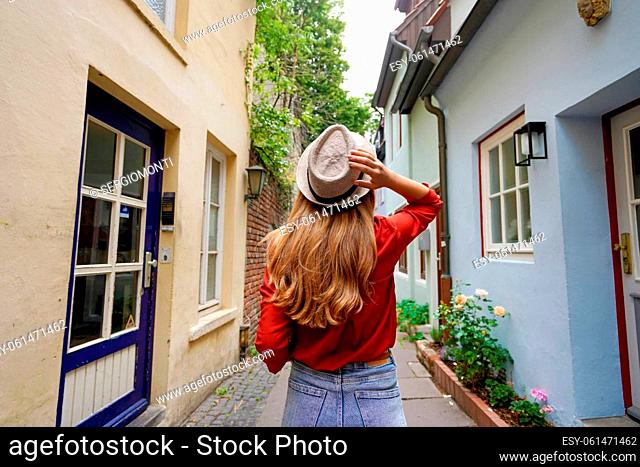 Beautiful traveler woman walking in Schnoor neighborhood, Bremen, Germany