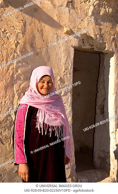 Berber Woman In Front Of Her Old Ancient Berber Village In Ksar In Metameur Near Djerba, Tunisia
