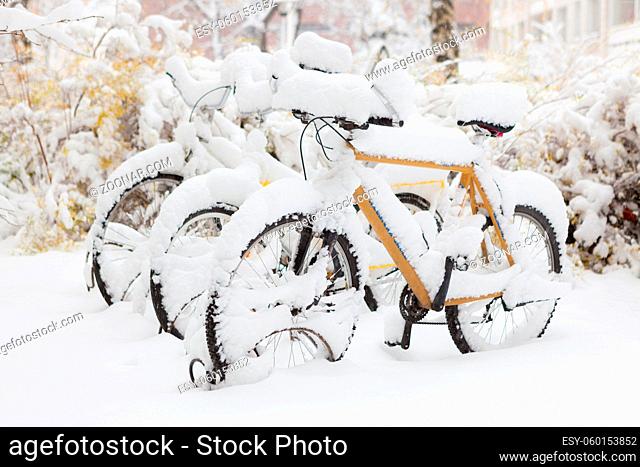Parked bicycle covered in snow outside
