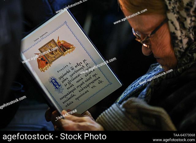 RUSSIA, MOSCOW - NOVEMBER 4, 2023: A woman holds a prayer book during a religious service marking the feast day of the Kazan icon of Our Lady at the Kazan...