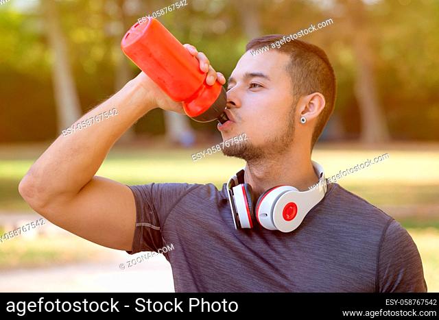 Drinking water runner young man running jogging sports training fitness workout outdoor