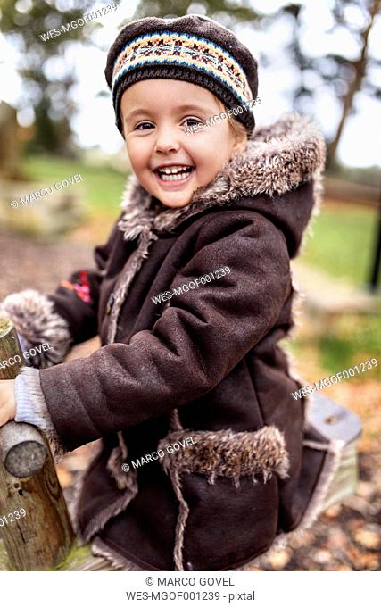 Portrait of happy little girl on a playground in autumn
