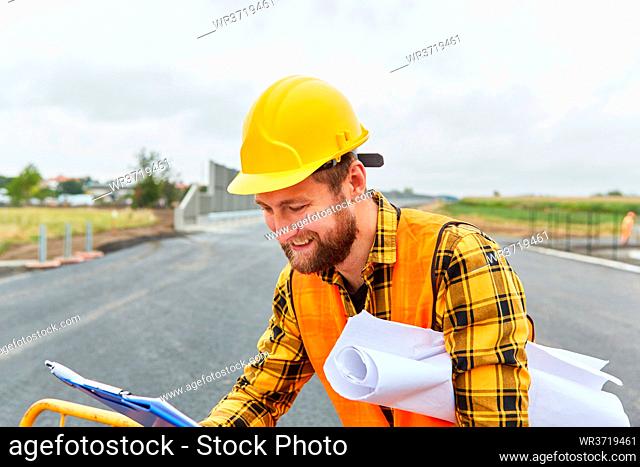 Bauarbeiter mit Checkliste und Bauzeichnung auf der Baustelle vom Straßenbau