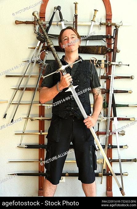 12 September 2022, Saxony, Leipzig: Fencing instructor Torsten Schneyer stands in front of a wall with weapons from 1450 to the 17th century