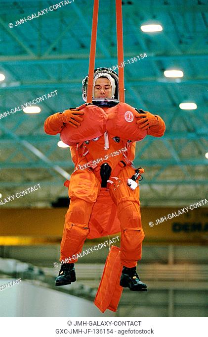 Astronaut Duane G. Carey, STS-109 pilot, simulates a parachute drop into water during an emergency bailout training session at the Neutral Buoyancy Laboratory...