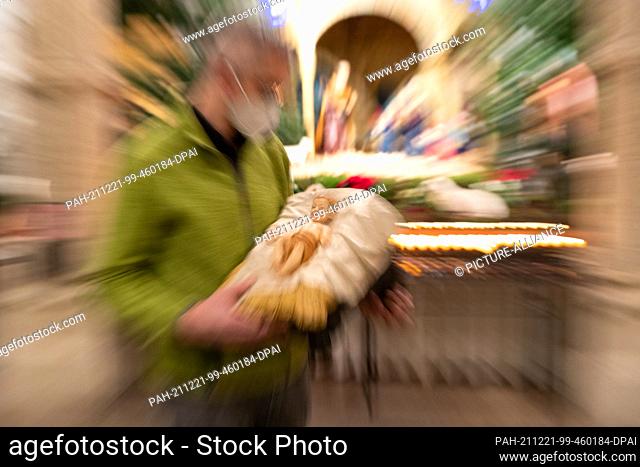 PRODUCTION - 17 December 2021, Lower Saxony, Osnabrück: Cathedral priest Ansgar Stuckenberg carries a Jesus figure (Christ Child) to its place in the crib of...