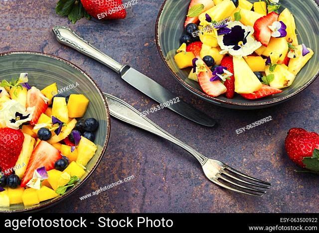 Delicious summer salad with field pansies and fruit