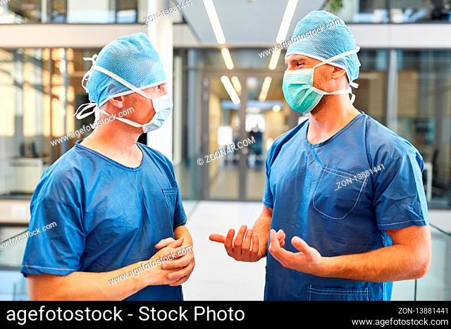 Zwei Chirurgen in blauer OP-Kleidung arbeiten zusammen in der Intensivstation