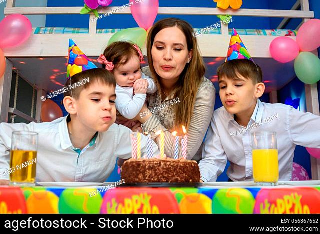 Family blowing candles on birthday cake