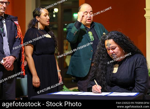 23 May 2023, Saxony, Leipzig: Christine Harvey (r), signs a return statement during a restitution ceremony for human remains of her people