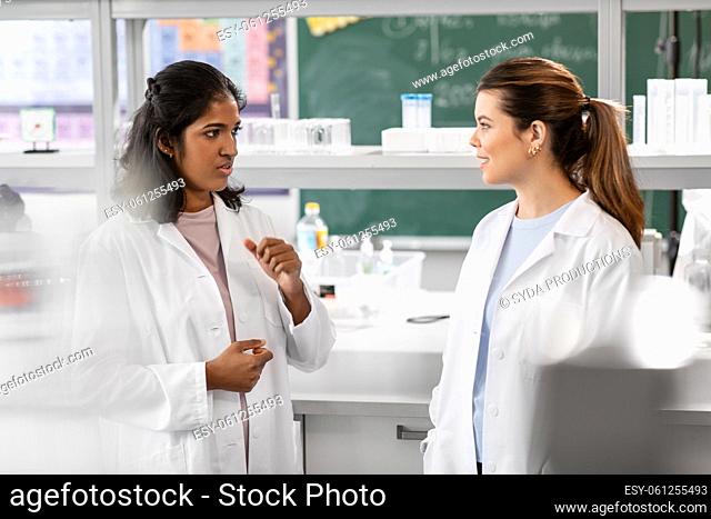 international female scientists talk in laboratory