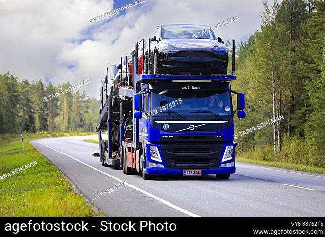 Blue Volvo FM car carrier Autolink Oy hauls Tesla and other new cars on road 25 from Hanko Port to mainland. Raasepori, Finland. September 9, 2021