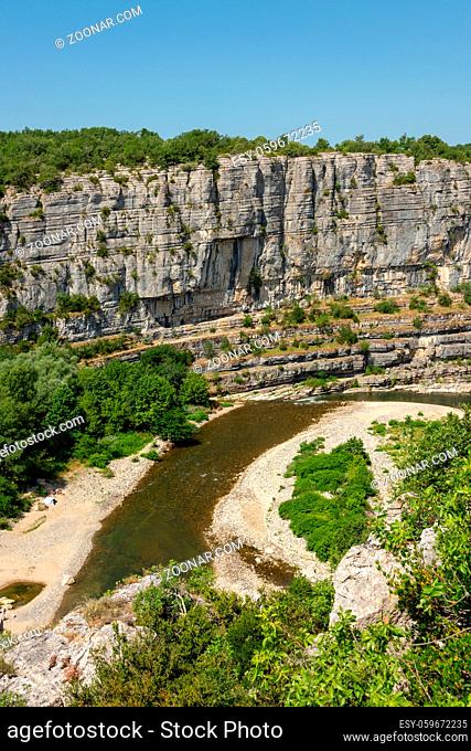 Landscape with the river Ardeche, framed by rock faces and much vegetation at