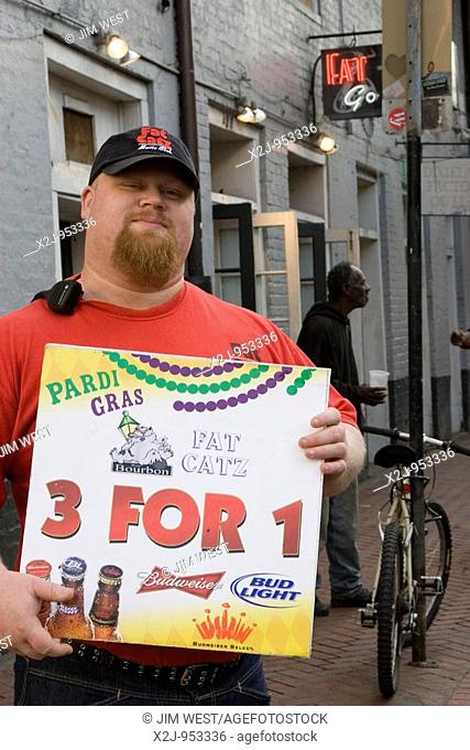 New Orleans, Louisiana - An employee of the Fat Catz bar advertises cheap beer to tourists on Bourbon Street in the French Quarter
