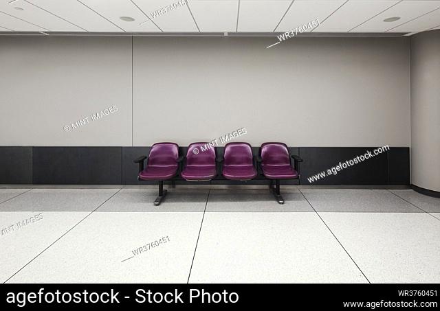 A row of four fixed seats in an empty airport
