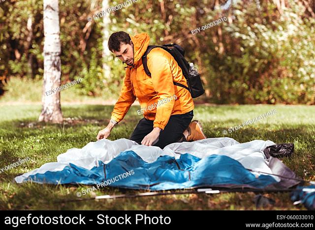 man setting up tent outdoors