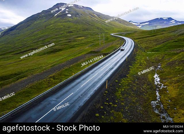 lonely car drive on beautiful remote road, travel background, aerial scenic landscape from iceland
