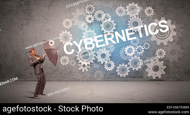Businessman defending with umbrella from CYBERNETICS inscription, technology concept
