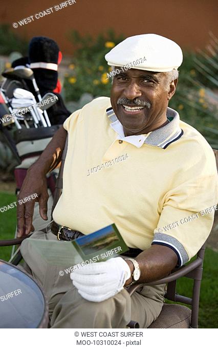 Senior man holding golf score card portrait