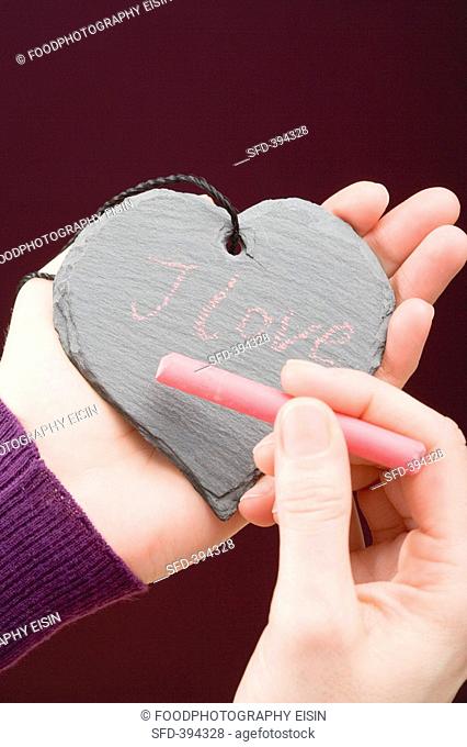Hand writing I love you in chalk on a slate heart