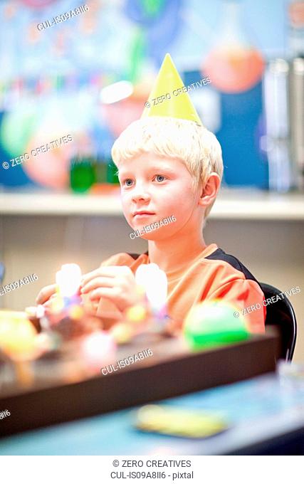 Boy at birthday party wearing party hat