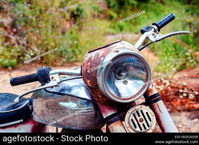 The thrown abandoned old rusty brown vintage motorcycle