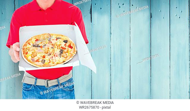 Delivery man holding pizza box against wooden background