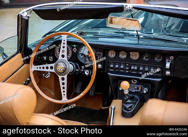 View into interior of left hand drive English historic classic sports car classic car roadster Jaguar E E-Type with steering wheel and dashboard
