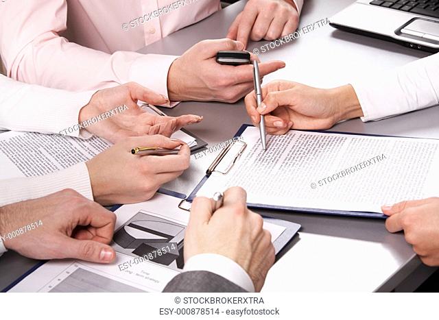Photo of business people hands working with documents at briefing