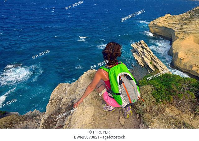 woman looking at the rock coast of Capo Pertusato, France, Corsica, Bonifacio