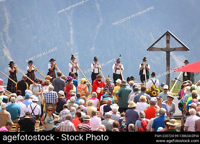 24 July 2022, Bavaria, Oberstdorf: Members of the alphorn group EUREGIO via salina make music at the 30th Berglar-Kirbe on the Fellhorn in front of the panorama...