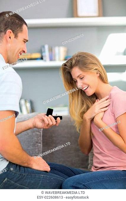 Man on one knee proposing to shocked girlfriend
